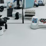 Microscópio e frascos dispostos em um laboratório equipado para análises científicas
