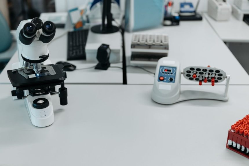 Microscópio e frascos dispostos em um laboratório equipado para análises científicas